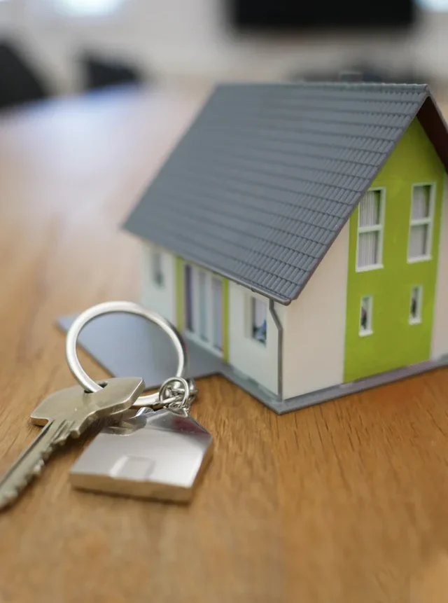 Casa de miniatura con llave sobre mesa